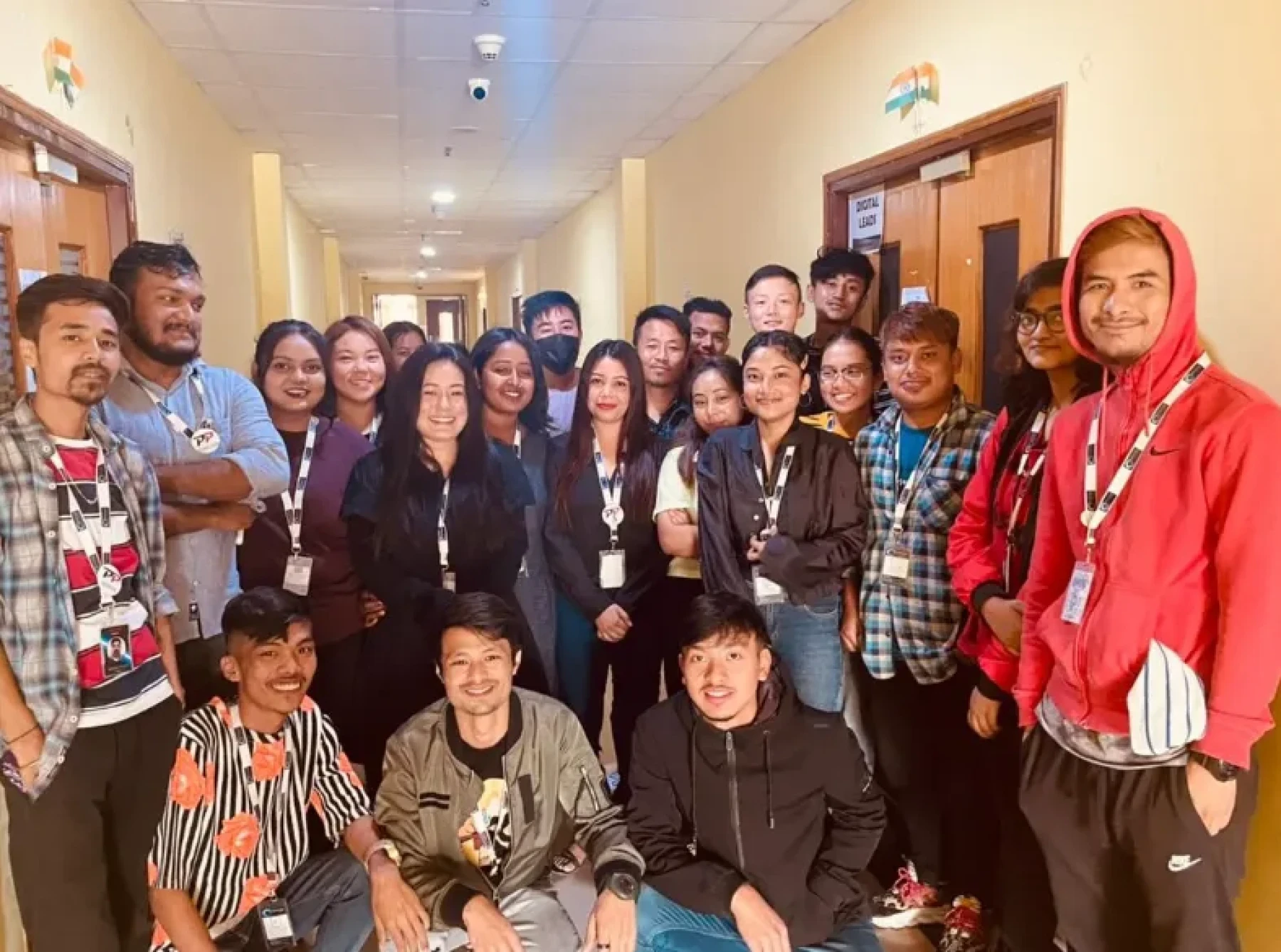 RHI team members wearing ID lanyards gathered for a group photo in an office hallway.